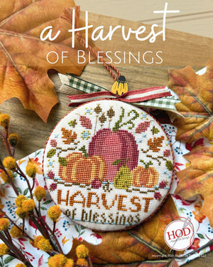 Cross-stitched design with 'Harvest of Blessings' text featuring fall leaves and pumpkins by Hands On Design.