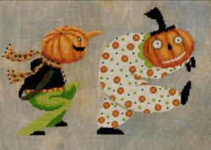 Two pumpkins in Halloween costumes on a textured fabric background