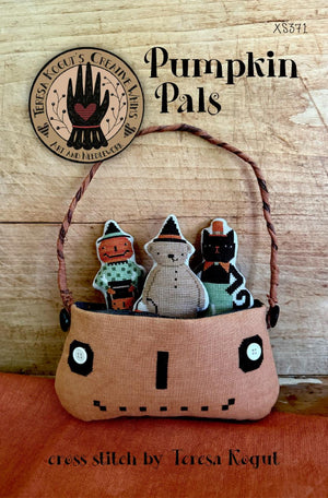 Cross stitch pattern for 'Pumpkin Pals' with a basket of pumpkin, bear and cat-themed figures by Teresa Kogut